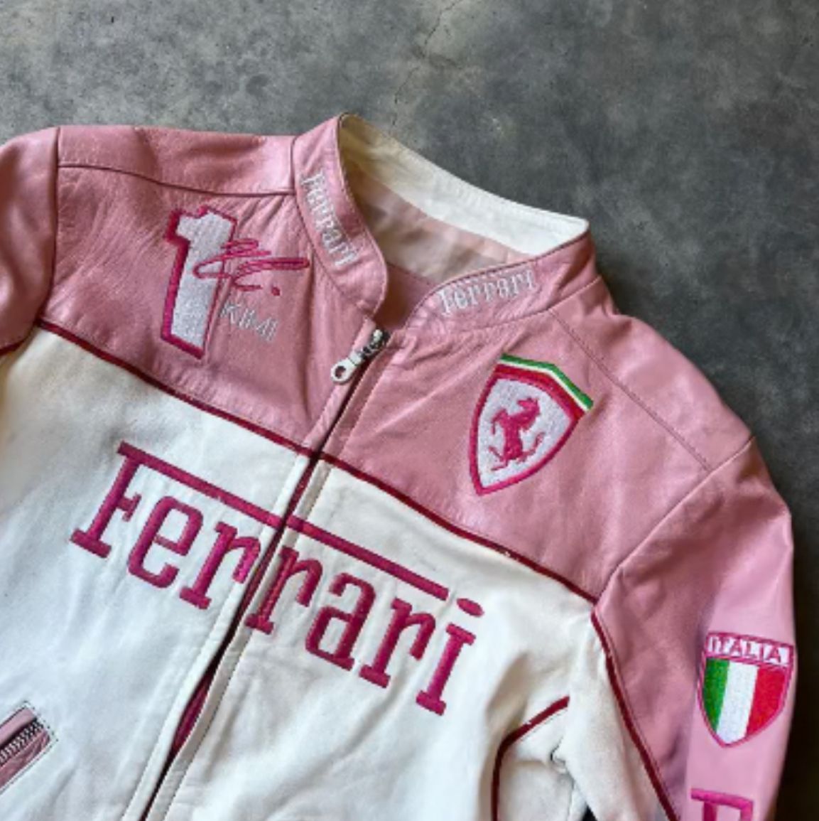 Close-up of Ferrari prancing horse embroidered on pink racing jacket