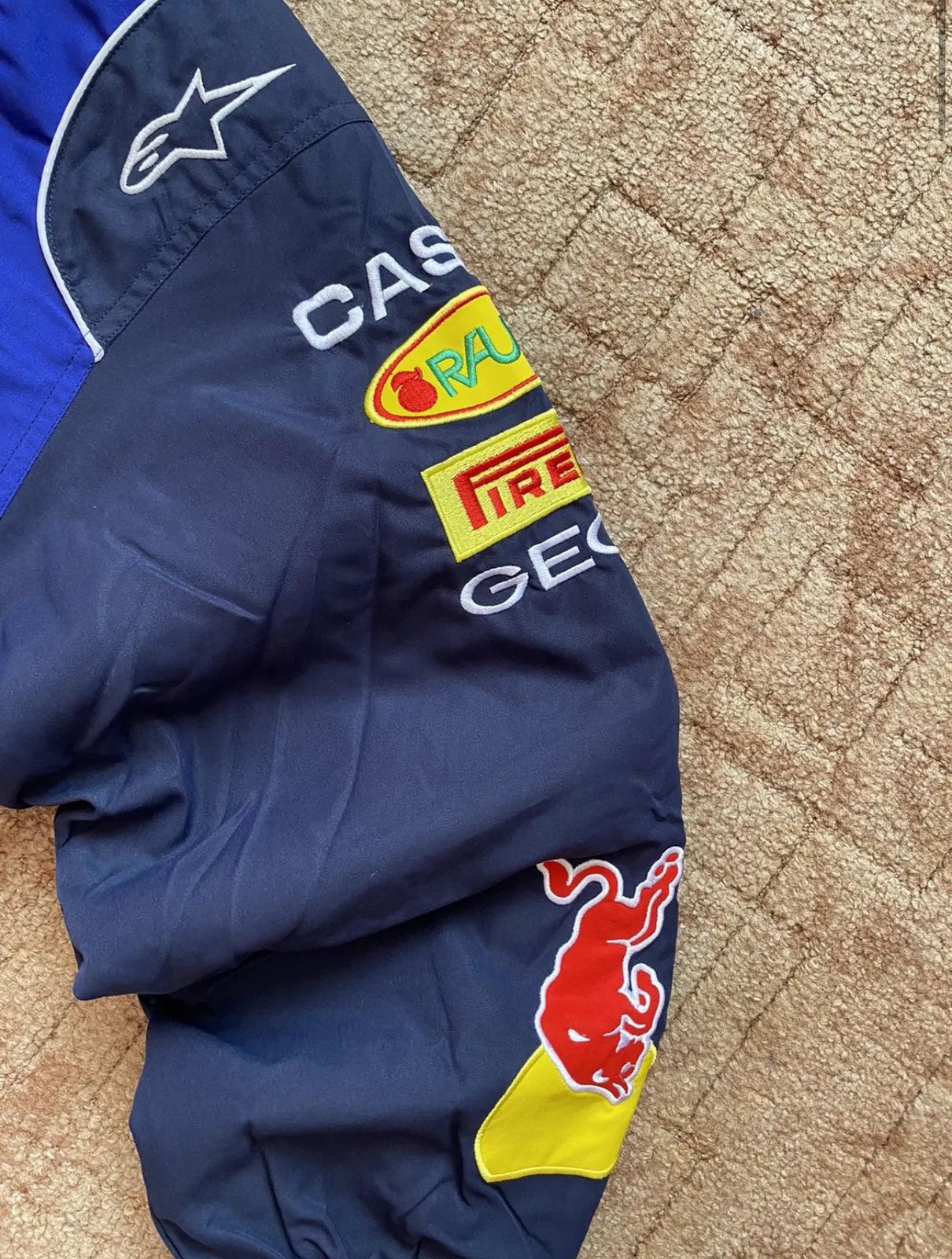 Close-up of embroidered Red Bull sponsor patch on F1 racing jacket